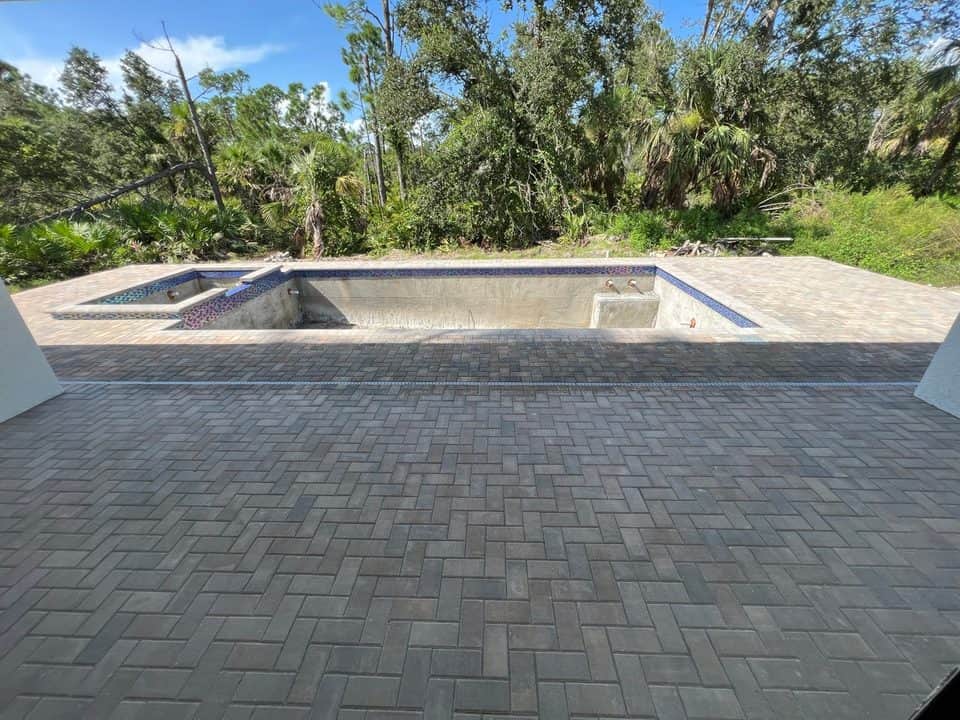 Paver pool deck with tiled spa from lanai | concrete and foundation work in Port Charlotte, FL by Sosnin Builders