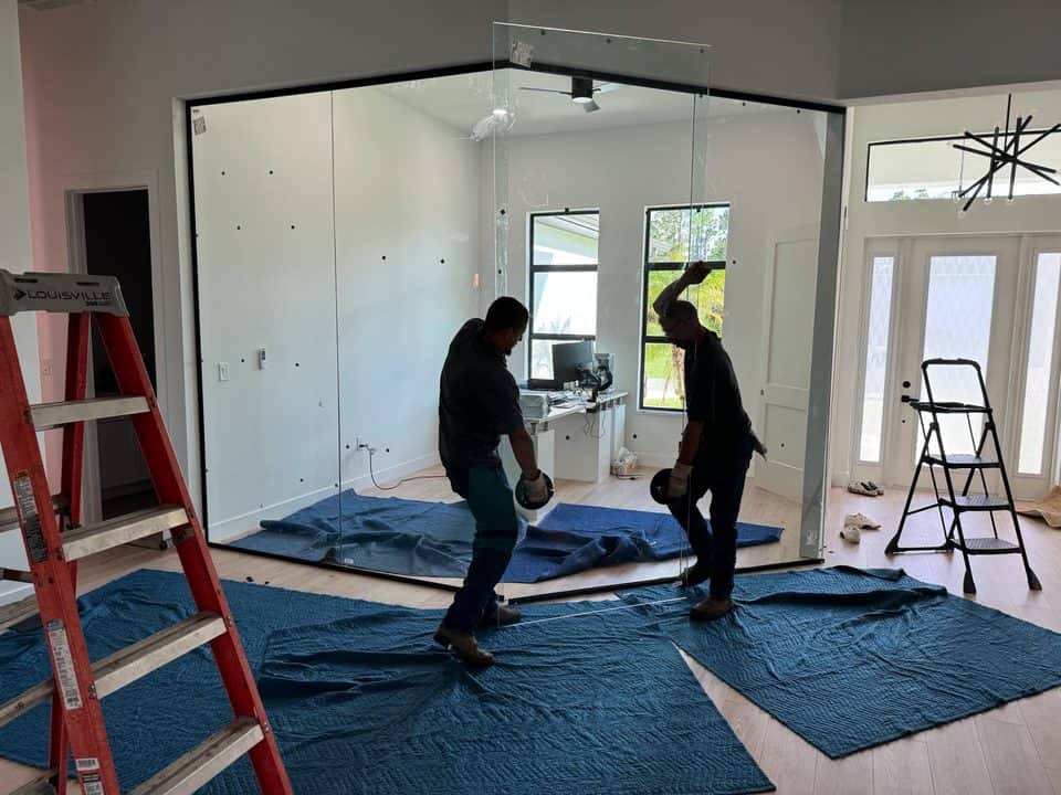 Crew installing glass office partition wall | construction work in progress in Port Charlotte, FL by Sosnin Builders