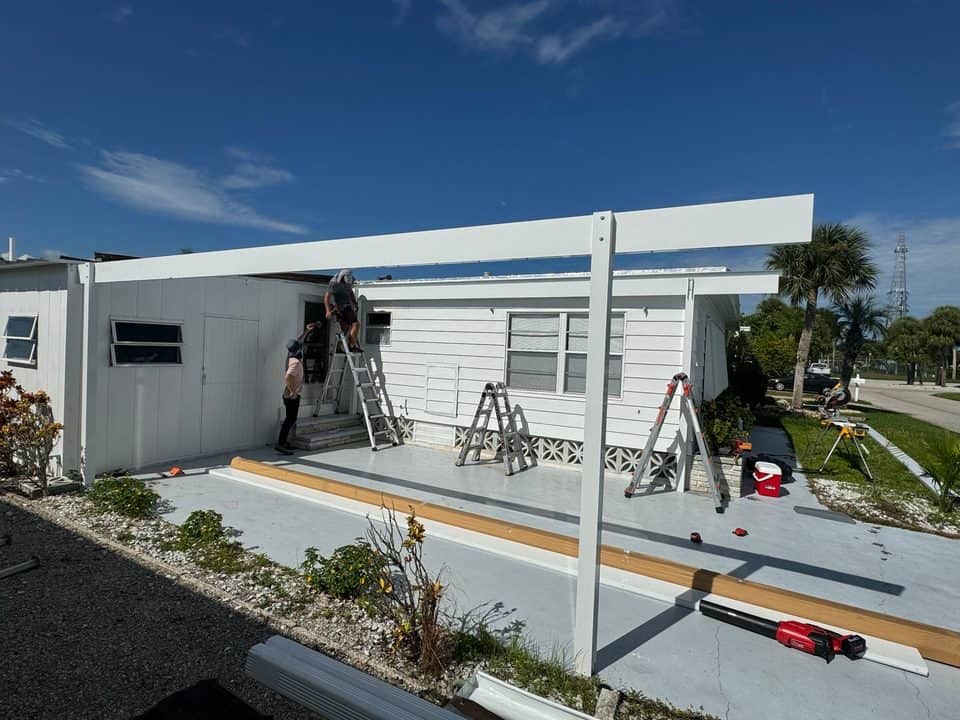 Carport beam installation, crew on ladders | construction work in progress in Venice, FL by Sosnin Builders