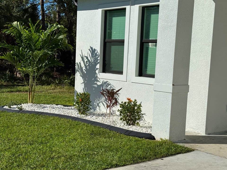 White-rock landscaping bed at home corner | custom home building in Port Charlotte, FL by Sosnin Builders