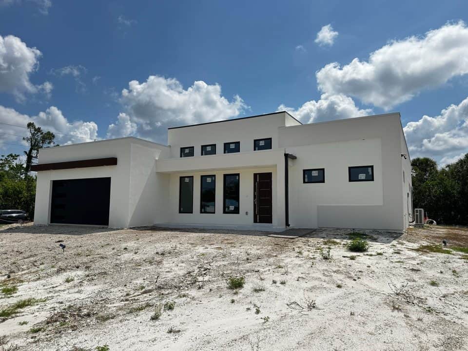 Modern white home exterior with dramatic clouds | new home construction in Englewood, FL by Sosnin Builders