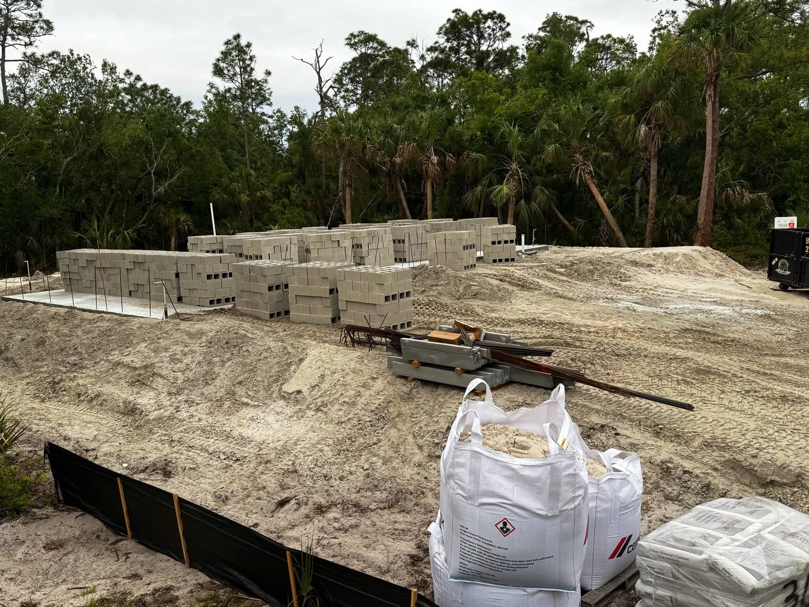 Blocks and cement staged on lot | concrete and foundation work in North Port, FL by Sosnin Builders