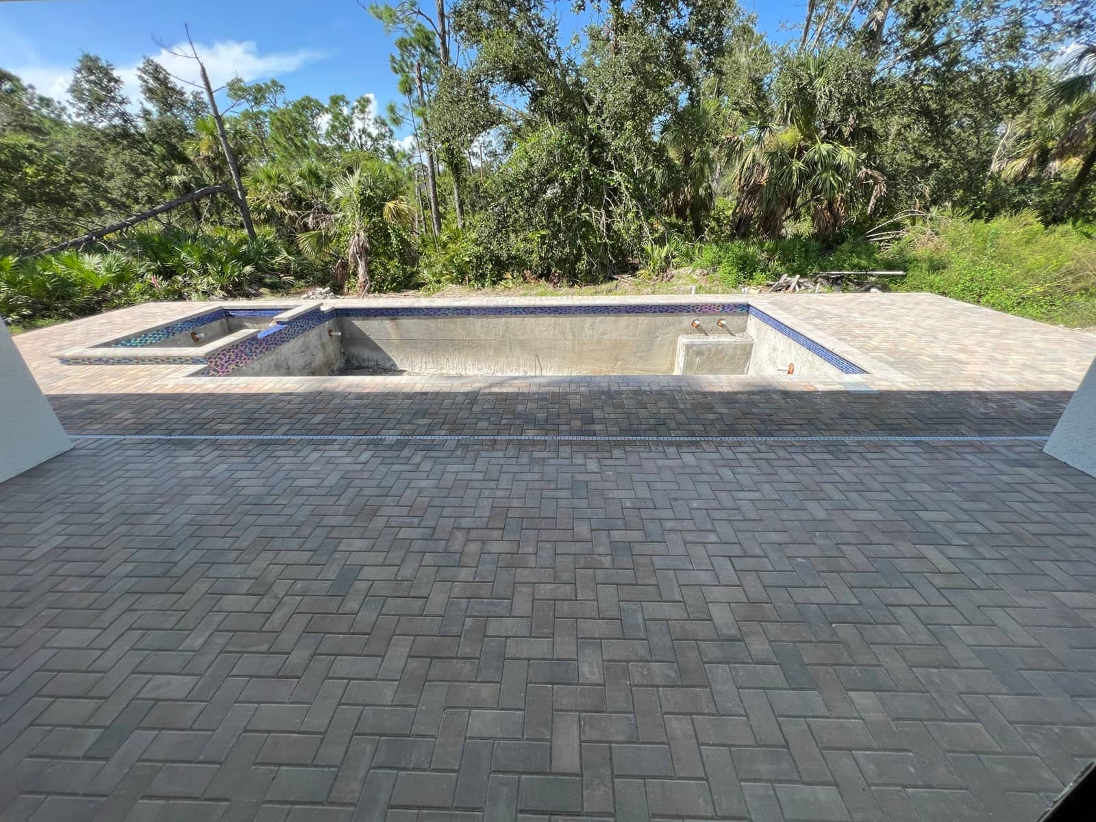 Paver pool deck with tiled spa from lanai | concrete and foundation work in Port Charlotte, FL by Sosnin Builders