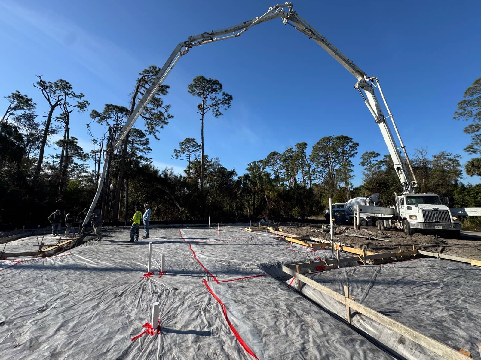 Concrete pump boom arched over slab pour prep | concrete and foundation work in Port Charlotte, FL by Sosnin Builders