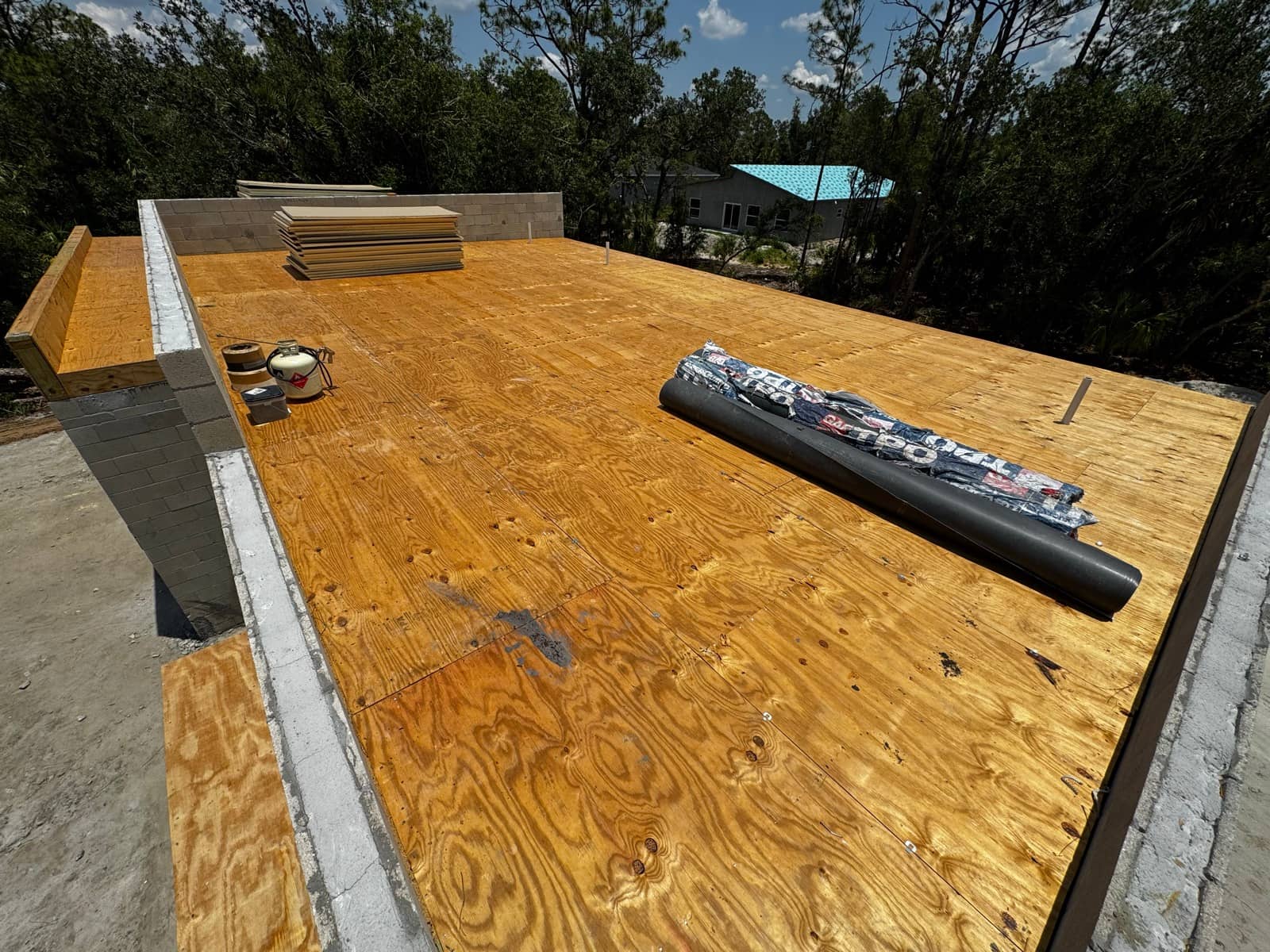 Roof deck sheathing with underlayment roll | construction work in progress in North Port, FL by Sosnin Builders