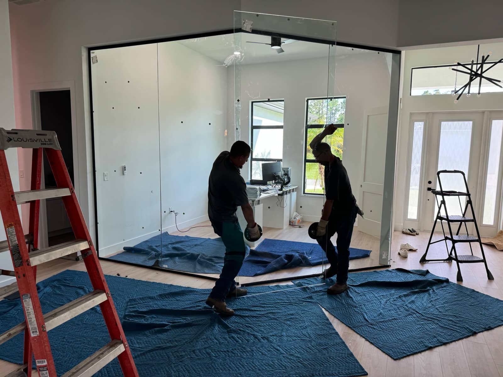 Crew installing glass office partition wall | construction work in progress in Port Charlotte, FL by Sosnin Builders