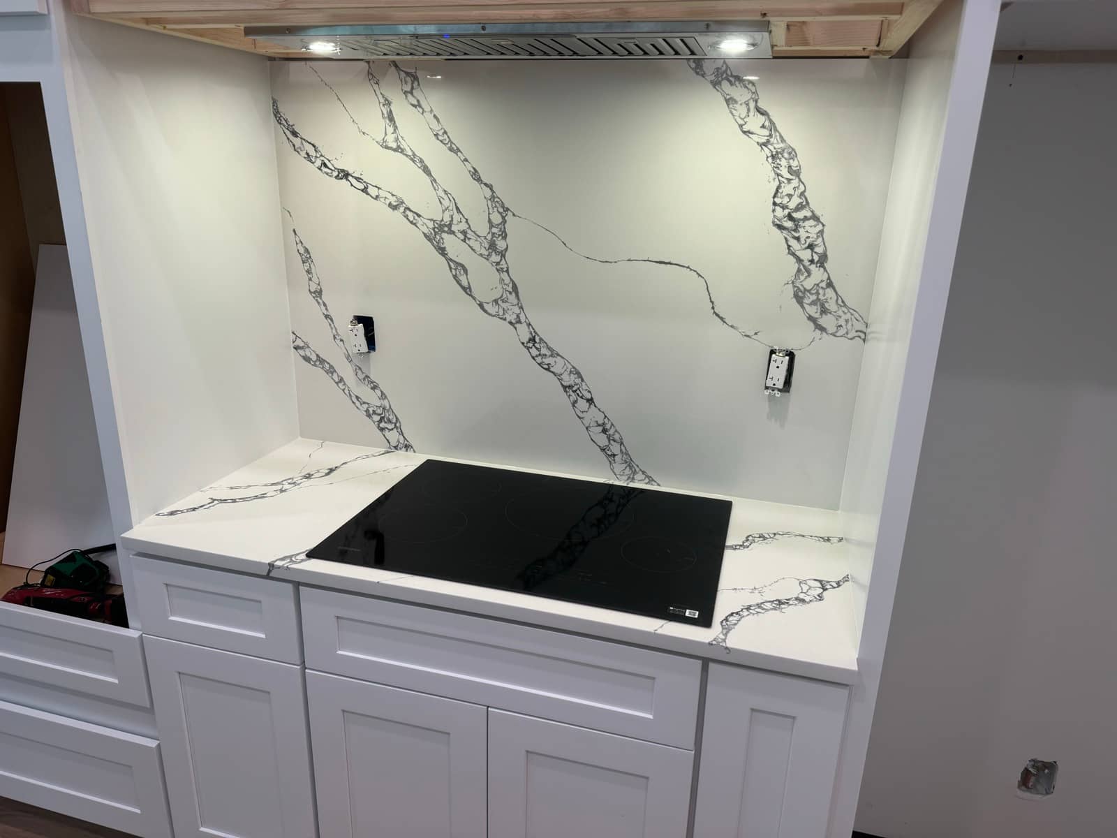 Quartz slab backsplash and cooktop install detail | custom home building in Port Charlotte, FL by Sosnin Builders