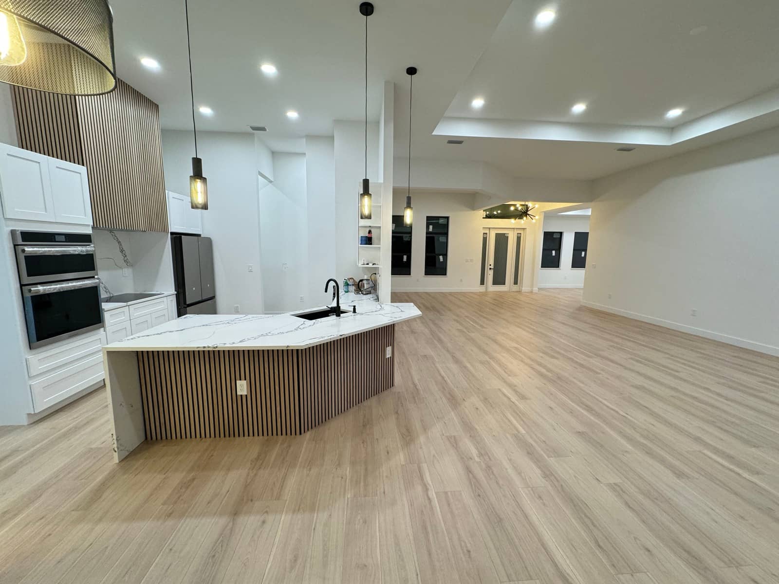 Finished open-plan kitchen and great room | custom home building in Port Charlotte, FL by Sosnin Builders