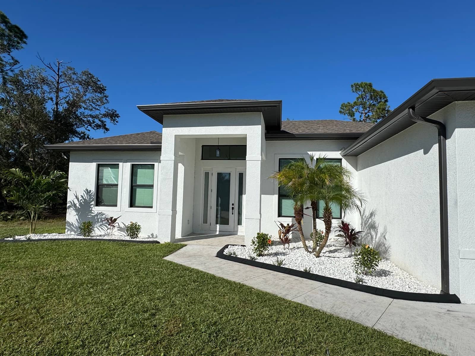 Finished white stucco home front exterior | custom home building in Port Charlotte, FL by Sosnin Builders