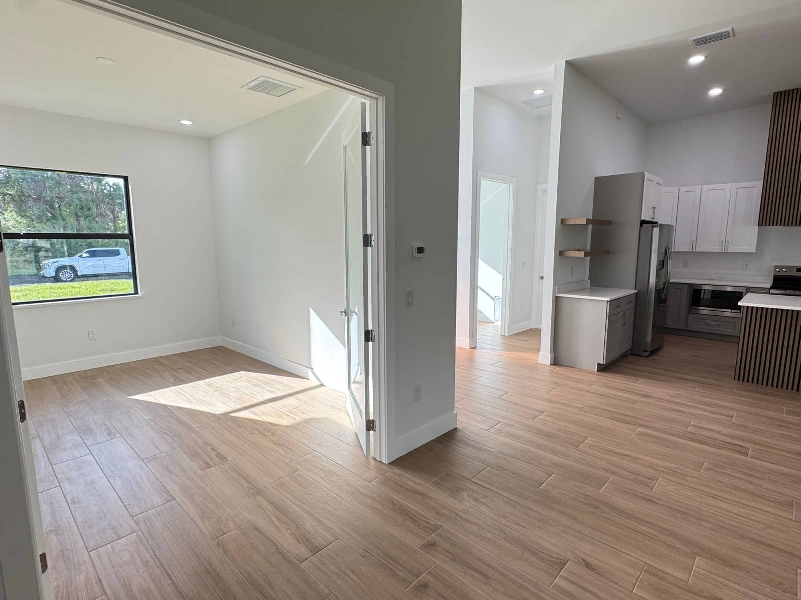 Finished interior, den and kitchen sight line | custom home building in Port Charlotte, FL by Sosnin Builders