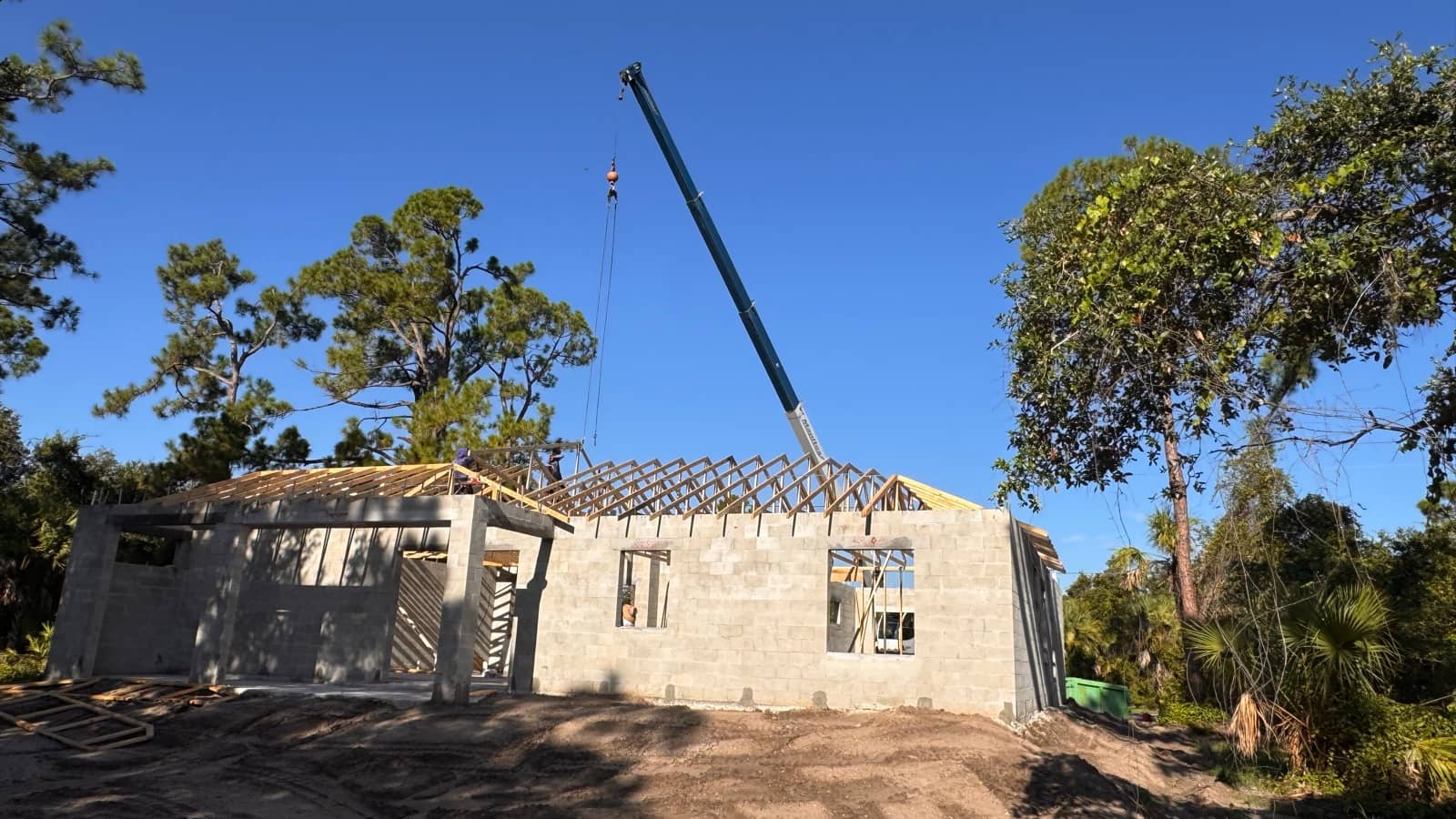 Crane setting roof trusses on shell | framing work in Port Charlotte, FL by Sosnin Builders