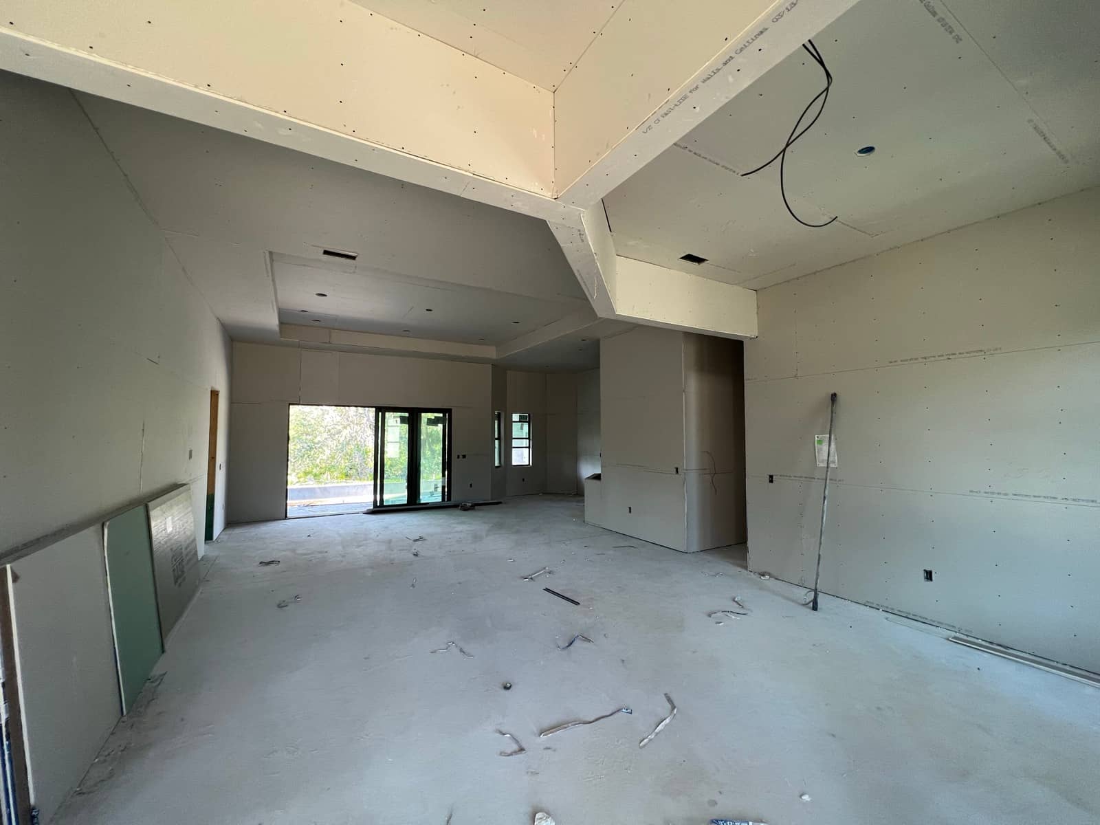 Drywall-stage interior with tray ceiling and beams | new home construction in Port Charlotte, FL by Sosnin Builders