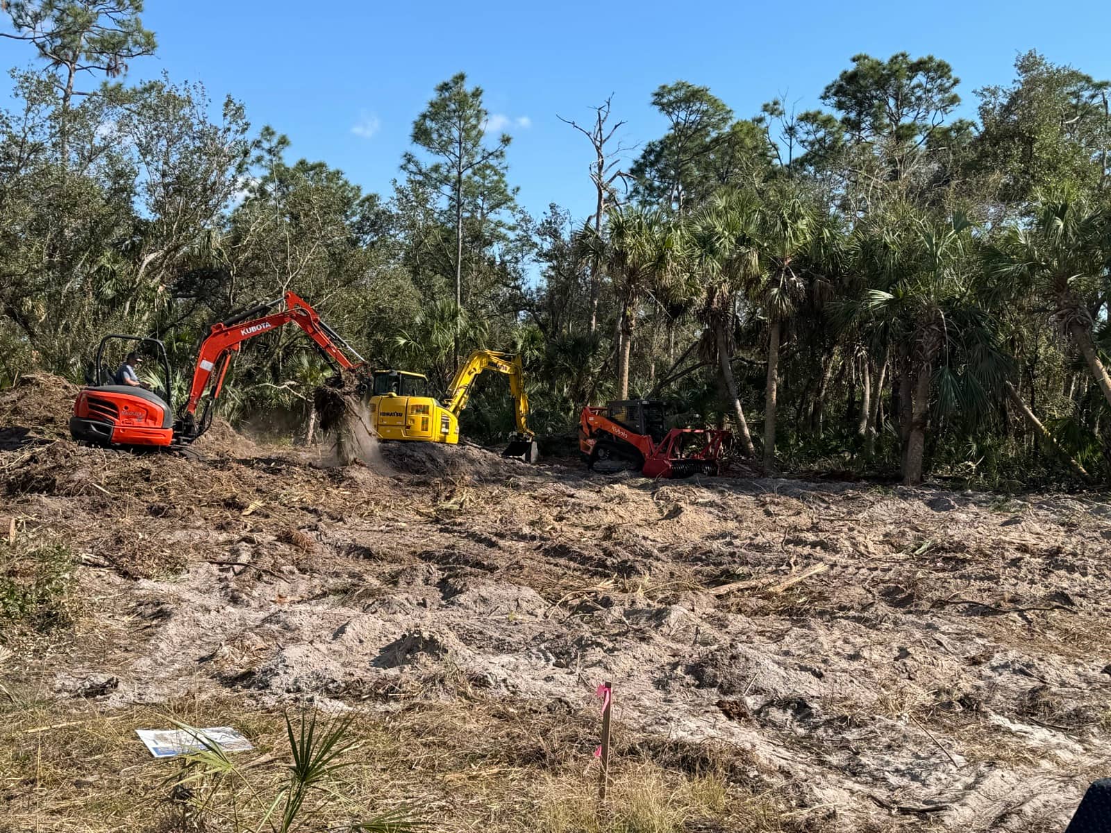 Three machines clearing wooded lot | site preparation and excavation in North Port, FL by Sosnin Builders