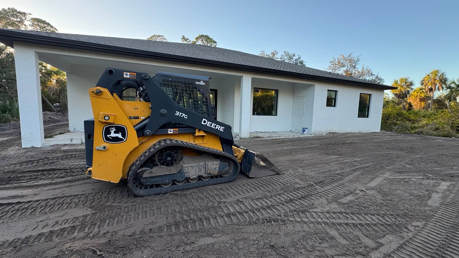 Track loader final grading at new home | site preparation and excavation in Port Charlotte, FL by Sosnin Builders