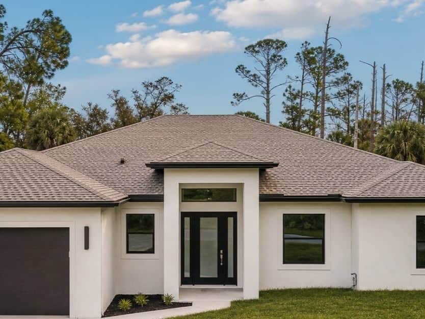 Completed Southwest Florida custom home with a hipped roof and black-framed windows