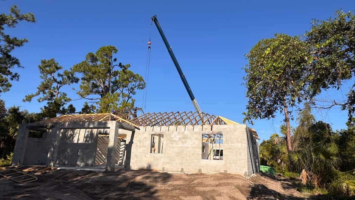 Crane setting roof trusses on shell | framing work in Port Charlotte, FL by Sosnin Builders
